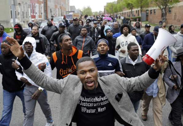 The Rev. Westley West leads a march for Freddie Gray to the Baltimore Police Department's Western District police station, Wednesday, April 22, 2015, in Baltimore. Gray died from spinal injuries about a week after he was arrested and transported in a police van. (AP Photo/Patrick Semansky)